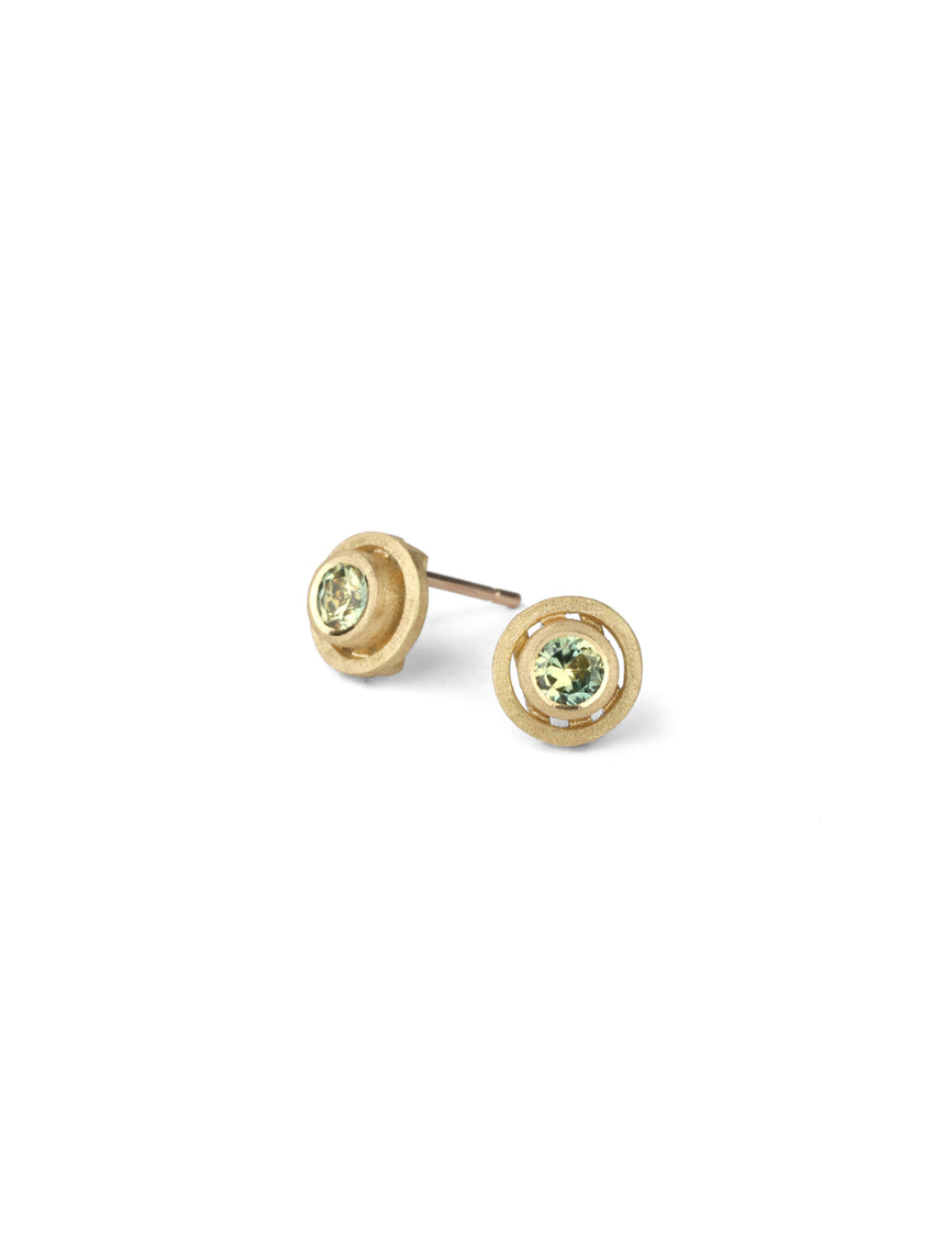 Yellow green sapphire ear studs with geometric circle detail. 18ct yellow gold, textured finish.