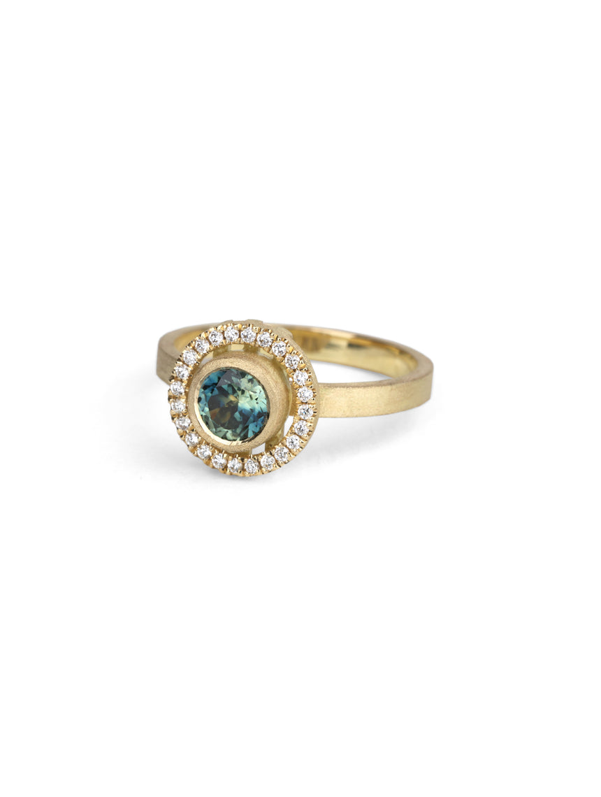 Blue green sapphire ring with a diamond halo, 18ct yellow gold textured finish.