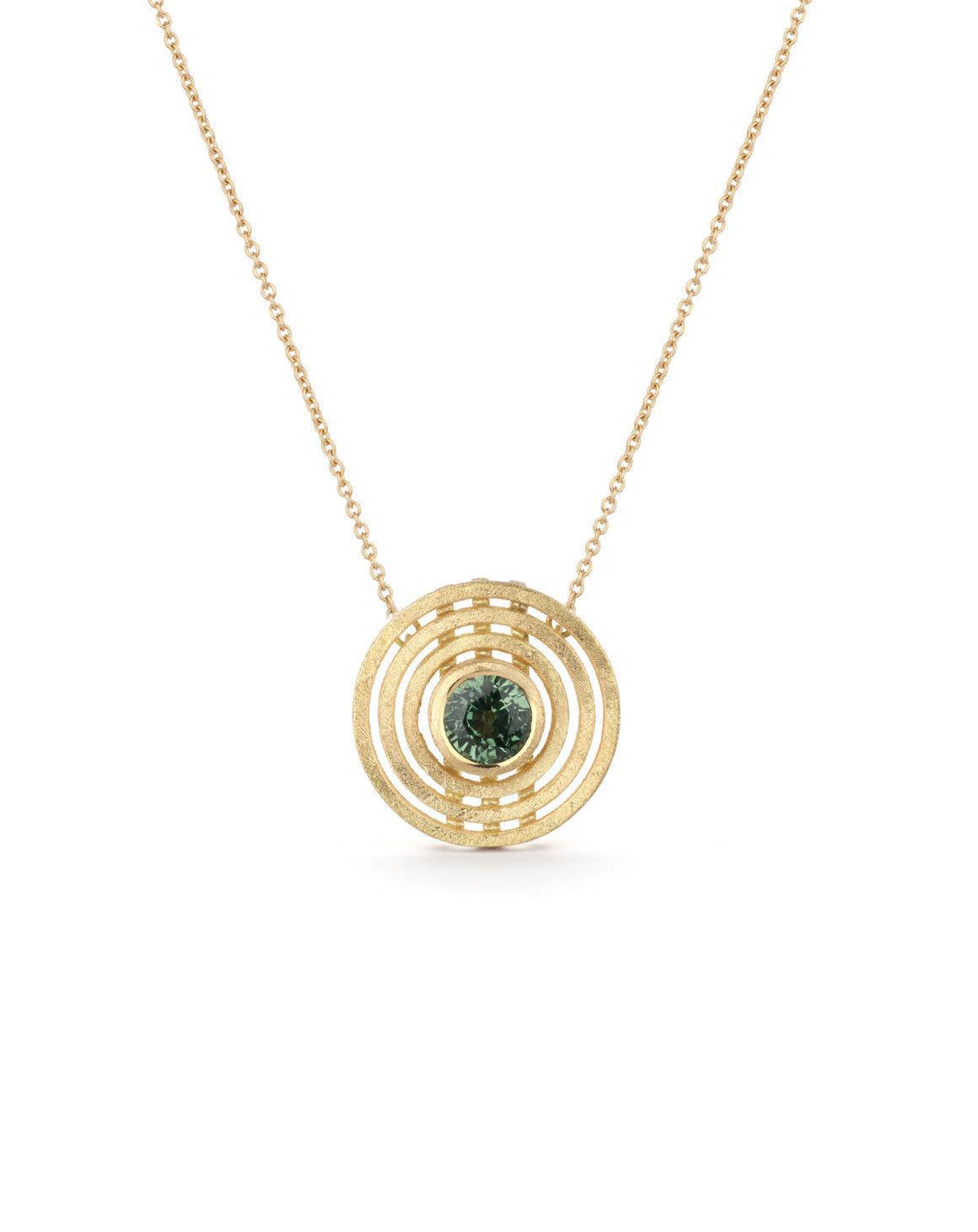 A pendant with round green sapphire surrounded by three circles. 18c yellow gold, textured finish.