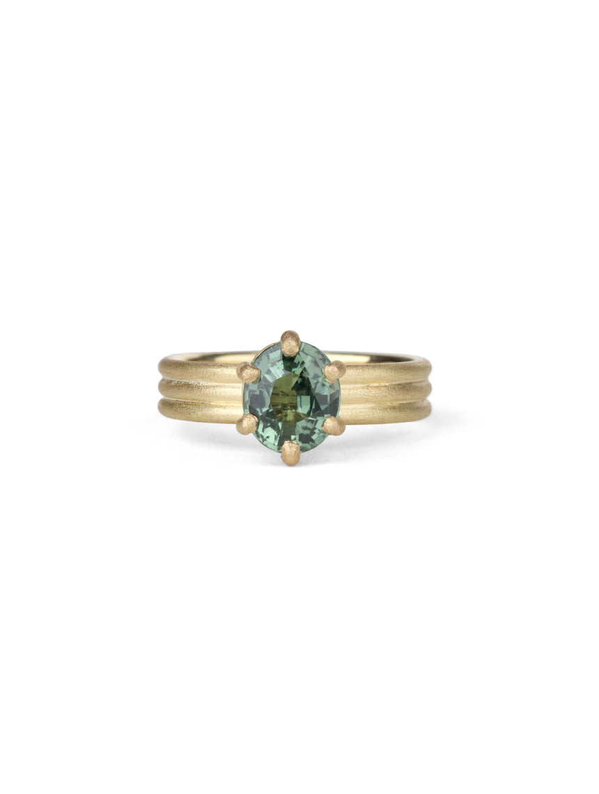 Oval green sapphire ring with six claw setting. On joined triple band, 18t yellow gold, textured finish.