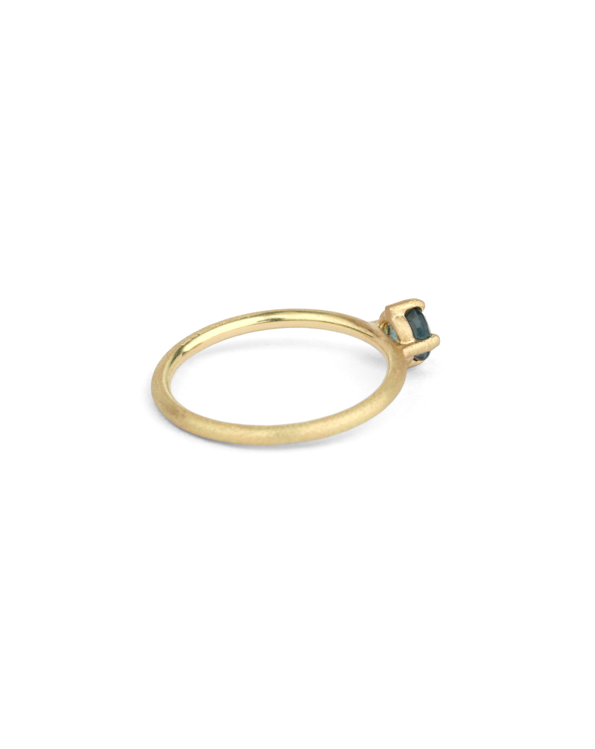 Solitaire ring in textured 18ct yellow gold with a round teal sapphire, side view